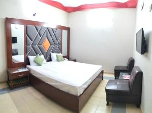 卡拉奇Subhan Palace Guest House的一间卧室配有一张床和一把椅子