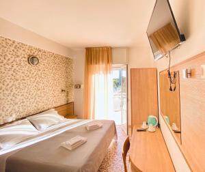 里米尼Hotel Ravello的酒店客房,配有床和电视