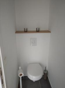 马尔梅迪Terrasses de Malmedy Lodge 417的浴室设有卫生间,在架子上放两个杯子