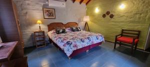 科塔德拉斯Hostal La Quebrada的一间卧室配有一张床和一把椅子