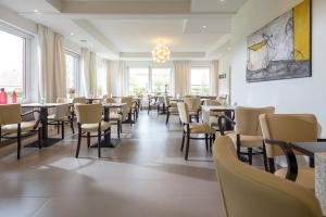 奈斯玛兹埃勒Hotel Villa Norderney的用餐室设有桌椅和窗户。