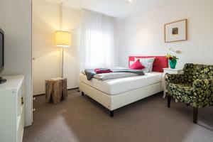奈斯玛兹埃勒Hotel Villa Norderney的一间小卧室,配有一张床和一把椅子