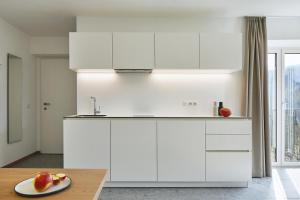 新波南特Casa Lies - Apartments的厨房配有白色橱柜和一张桌子上的一盘水果