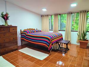 圣伊格纳西奥玛娅山林小屋的一间卧室配有一张带彩色毯子的床