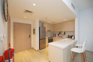 阿布扎比Yas Island - 2 Bedrooms, 2 toilet with shared Pool & Parking的厨房配有白色的柜台和冰箱。