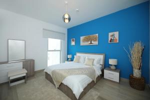 阿布扎比Yas Island - 2 Bedrooms, 2 toilet with shared Pool & Parking的一间蓝色卧室,配有一张床和电视