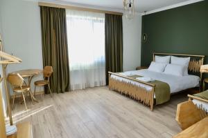 塞凡Sargsyan ECO house的一间卧室配有一张大床和一张桌子及椅子