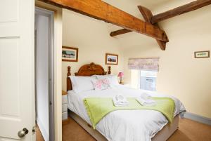 克里克豪厄尔The Neuadd Cottages的一间卧室配有一张床,上面有两条毛巾