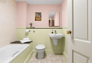 克里克豪厄尔The Neuadd Cottages的浴室配有卫生间、盥洗盆和浴缸。