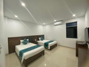 下龙湾Minh Hưng Motel的客房设有两张床、一台电视和一台电视。