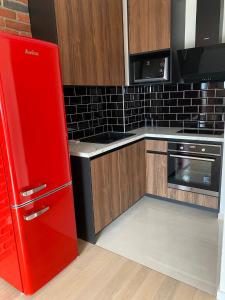 萨格勒布Arena ZG Apartment的带木制橱柜的厨房内的红色冰箱