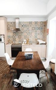 希斯泰洛Casa do Ferreiro的厨房配有木桌和白色椅子