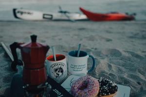 包姚Fekete Gólya Pihenőház的海滩上有两个咖啡杯和两个甜甜圈