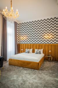 萨图马雷Hotel Vila Central Boutique Satu Mare的一间卧室配有一张带吊灯的大床
