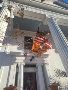 米斯蒂克1833之家住宿加早餐旅馆的悬挂在建筑物一侧的美国国旗