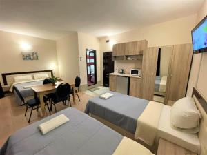 斯维什托夫Хотел Дунав Свищов的酒店客房设有两张床、一张桌子和一间厨房。