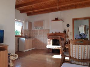 普里耶多尔Vikendica Kristina的厨房配有壁炉、桌子和椅子