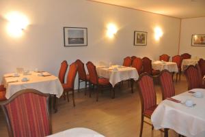 哈根艺术环境酒店的用餐室配有桌椅和白色的桌布