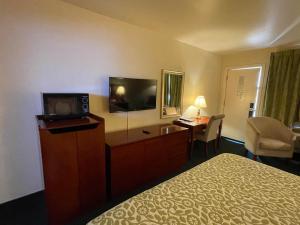 德明Days Inn by Wyndham Deming的配有一张床和一台平面电视的酒店客房