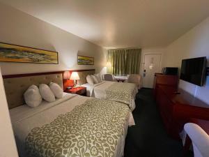 德明Days Inn by Wyndham Deming的酒店客房设有两张床和一台平面电视。