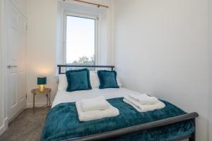 阿伯丁Brulee House - Luxury 2 Bed Apartment in Aberdeen Centre的一间卧室配有一张床,上面有两条毛巾