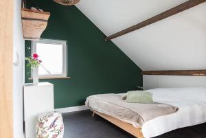 德吕嫩La Casa Gardenia的绿色卧室设有床和窗户