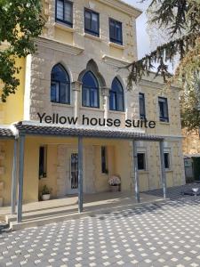迈季代勒舍姆斯Yellow House Suite的黄色房子,前面有标志