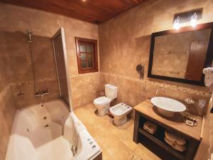 埃尔卡拉法特拉卡提亚精品酒店的带浴缸、盥洗盆和卫生间的浴室