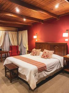 埃尔卡拉法特拉卡提亚精品酒店的一间卧室设有一张带红色墙壁的大床