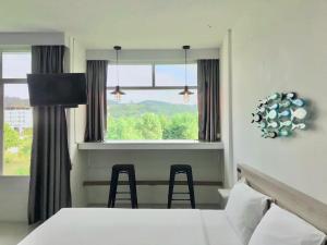 奈扬海滩慢生活海滩旅馆的客房设有床、窗户和椅子。