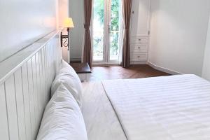 胡志明市HOME by FLATTO APARTMENT的卧室配有白色的床和窗户。