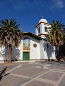 卢汉德库约Departamento Carrodilla Luján的前面有两棵棕榈树的教堂