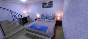 穆卡切沃Двухярусная квартира в центре Мукачева, улица Мира的一间卧室配有一张带蓝色枕头的床,并设有一个楼梯