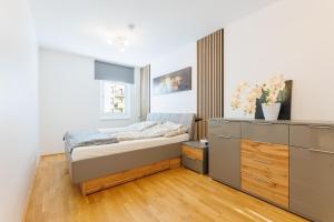 维也纳Home in Vienna by Oberlaa Therme - 15 min to the city center的一间小卧室,配有一张床和一个梳妆台