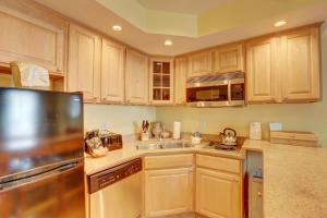 哈特勒斯Villas of Hatteras Landing by KEES Vacations的厨房配有木制橱柜和不锈钢冰箱。