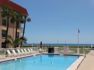 可可比奇Spanish Main Unit 4- Direct Oceanfront Condo!的一个带椅子的游泳池,背景是大海