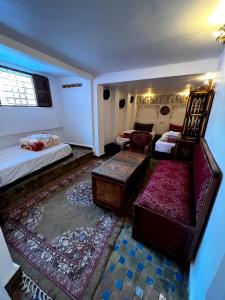 非斯Riad dar Kirami的客房设有两张床、椅子和沙发。