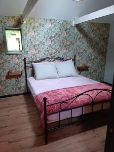 KoedijkVakantiewoning De Koolboet的一间卧室配有一张带花卉壁纸的床