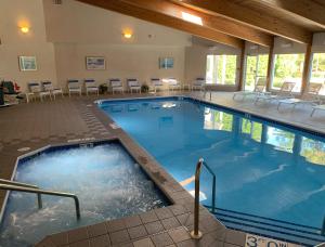 鱼溪AppleCreek Resort-Hotel & Suites的酒店的大型游泳池配有桌椅