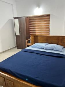 卡尔佩特塔Wayanad Biriyomz Residency, Kalpatta, Low Cost Rooms and Deluxe Apartment的一间卧室配有一张大床和木制床头板