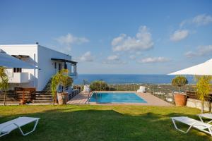 马鲁拉斯Villa Vigles的一座带游泳池和大海的别墅