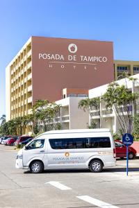 坦皮科波萨达德坦皮科酒店的停在大楼前停车场的白色货车