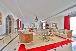 杰尔吉斯DAR OOMI的带沙发和红色地毯的大型客厅