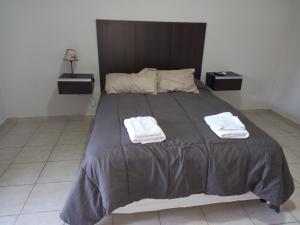 La ConsultaNueva Era Apart的一间卧室配有一张大床和两条毛巾
