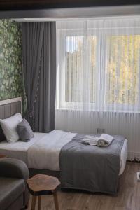 埃伯斯瓦尔德菲诺亚曼酒店的一间卧室设有两张床、一张沙发和一个窗口