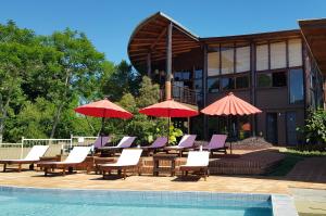 埃尔索韦维奥Puro Moconá Lodge的一组椅子和遮阳伞,位于游泳池旁