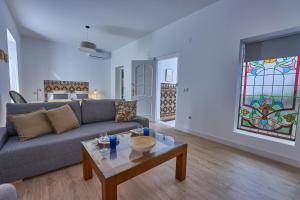 塞维利亚Casa Pureza的客厅配有沙发、桌子和彩色玻璃窗