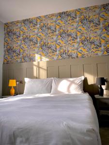 EwhurstThe Bulls Head Inn的一间卧室配有一张蓝色和黄色壁纸的大床