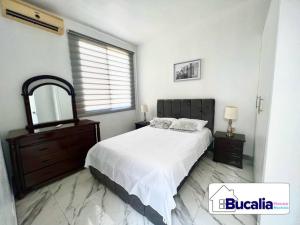马查拉Bucalia House Machala的一间卧室配有一张床、梳妆台和镜子
