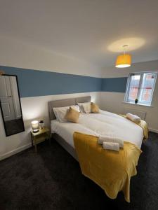 德比Erasmus House - 3 Bedrooms - City Centre, Netflix, WIFI, Free Private Parking的一间卧室配有一张大床,床上有黄色的毯子